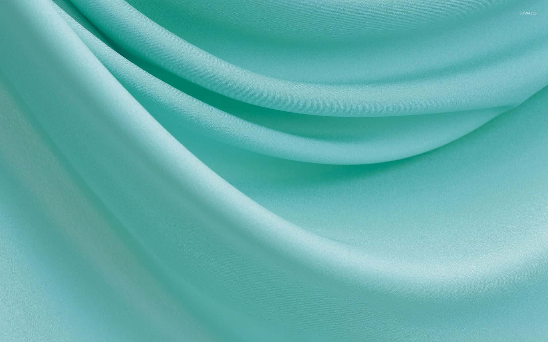 Turquoise Blue 桌布 壁紙 — 柔軟流動的綠松石布料，帶有柔和曲線和細微光線反射，營造寧靜簡約的質感。