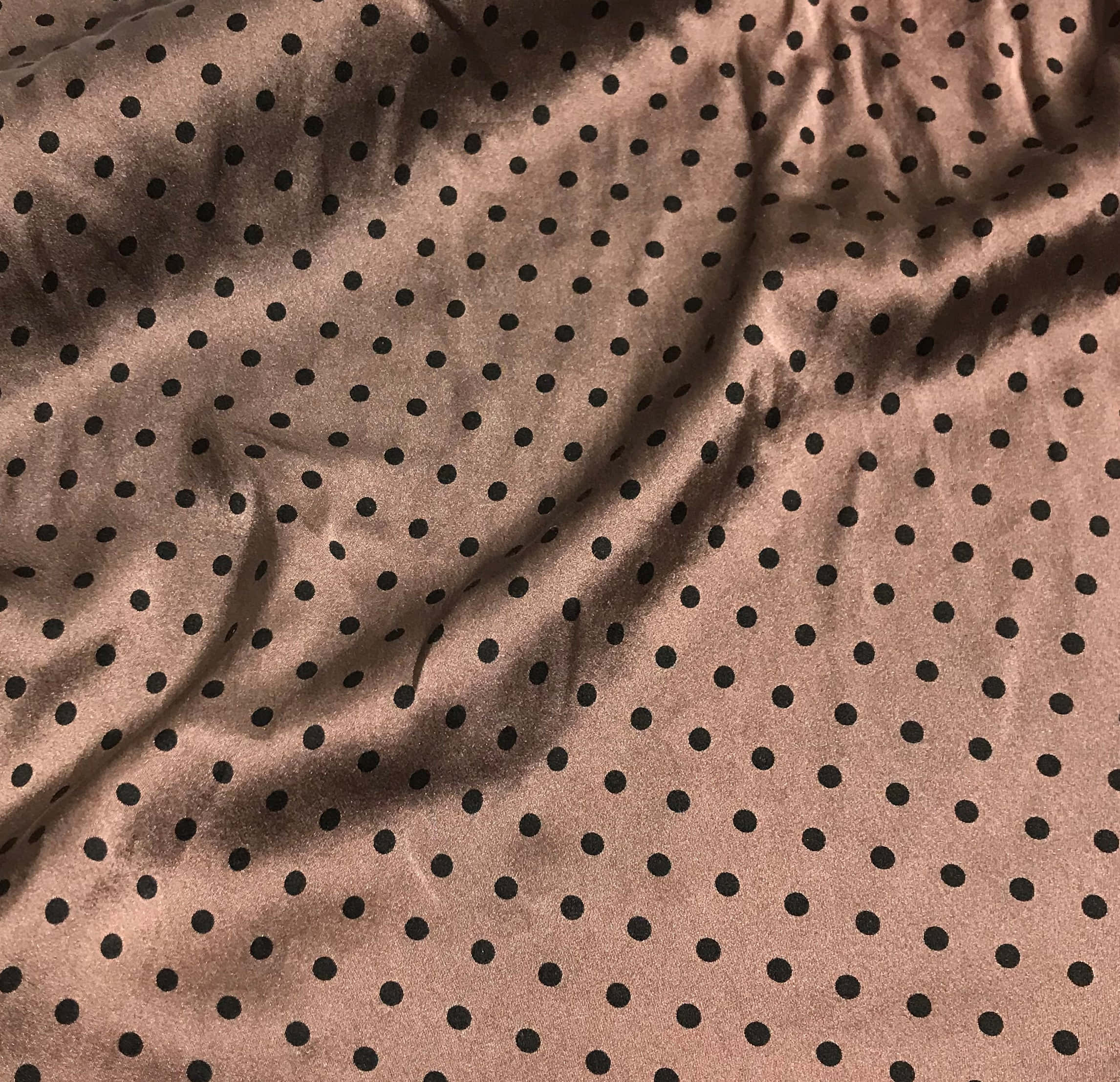 Brown Polka Dots 桌布 壁紙 — 柔軟灰褐色天鵝絨布料近距離特寫，帶有黑色圓點圖案，以柔和褶皺垂墜。