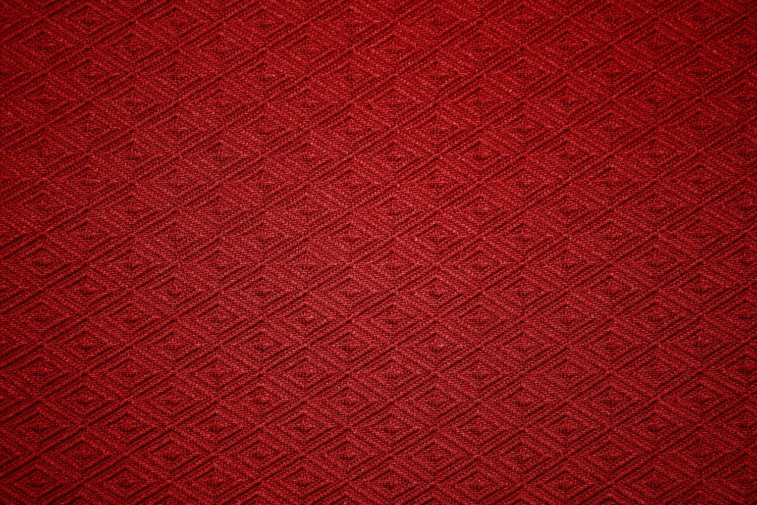Fabric 桌布 壁紙 — 柔軟燈光下，帶有複雜菱形編織圖案的濃郁深紅色布料。
