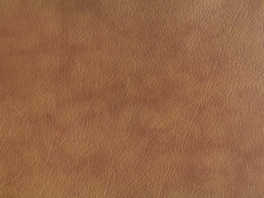 Brown Texture 桌布 壁紙 — 柔軟燈光下，豐富棕色皮革的特寫，帶有自然皺褶和細微色調變化。