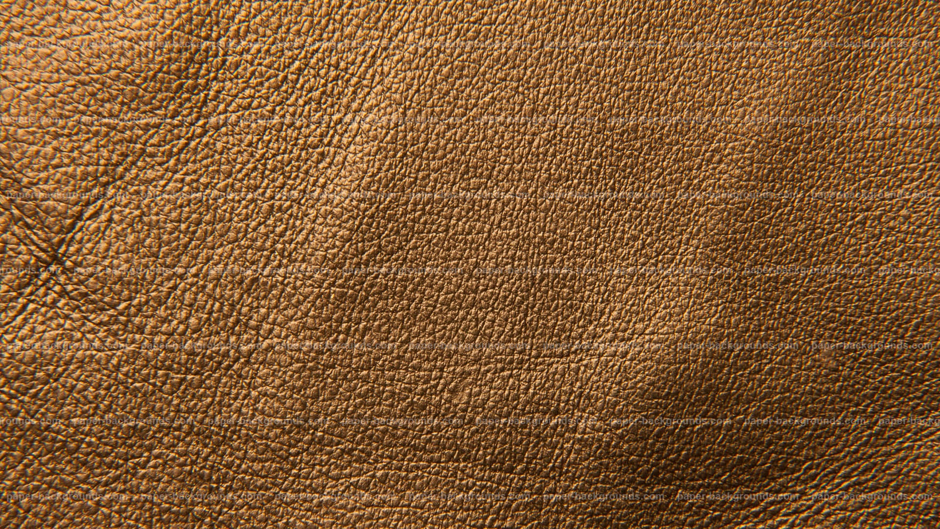 texture 桌布 壁紙 — 柔軟燈光下，豐富棕色皮革的特寫，展現天然紋理與細微皺褶。
