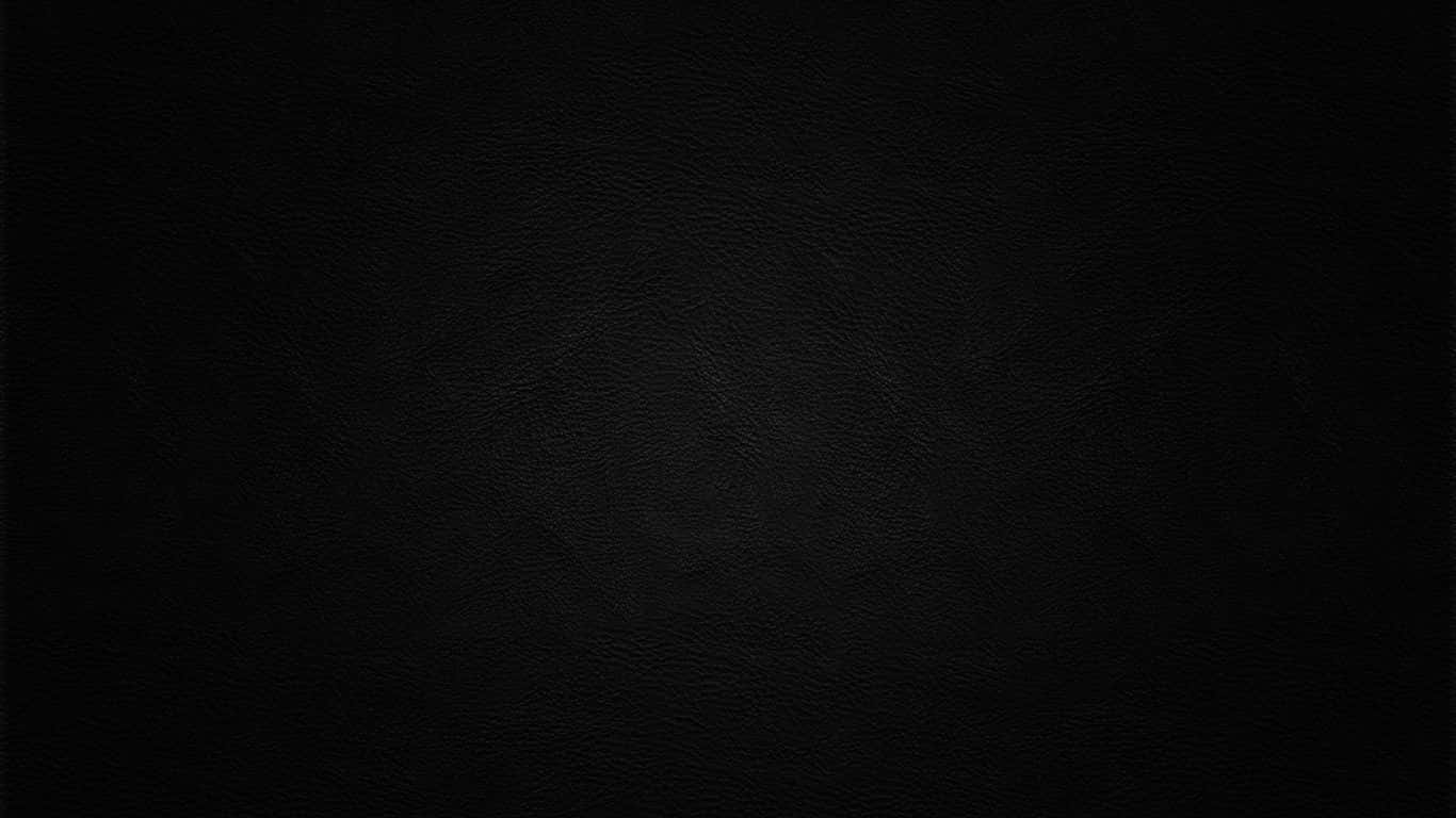 Dark Textured 桌布 壁紙 — 柔軟燈光下光滑黑色皮革表面的特寫，帶有細微的粒面紋理。