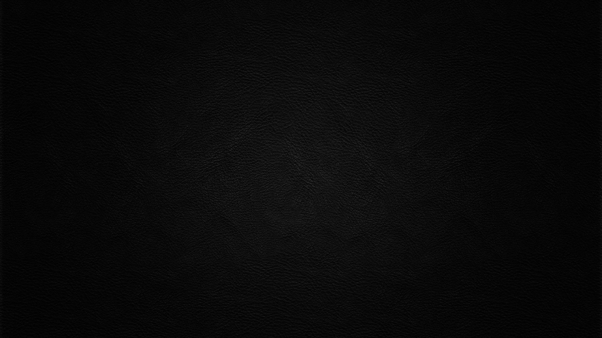 Wall Texture 桌布 壁紙 — 柔軟燈光下光滑黑色皮革表面的特寫，帶有細微的粒面紋理。