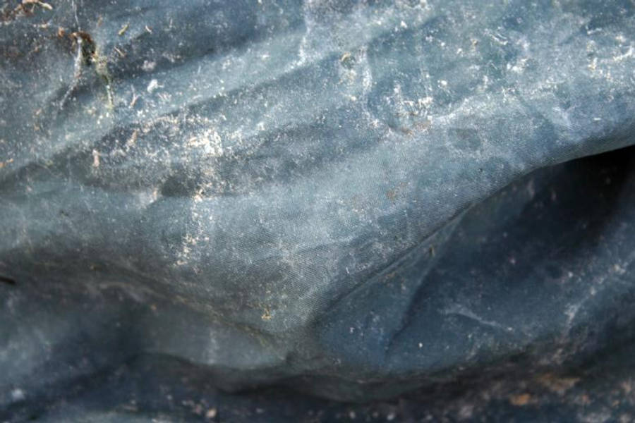 藍色紋理 桌布 壁紙 — 柔軟燈光下帶有白色斑點和皺褶的紋理藍灰色布料特寫。