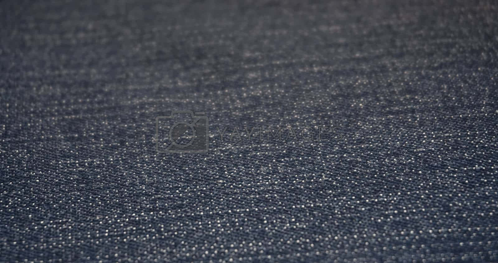 Textured 桌布 壁紙 — 柔軟燈光下深色牛仔布料的特寫，可見織紋和細微白色斑點。