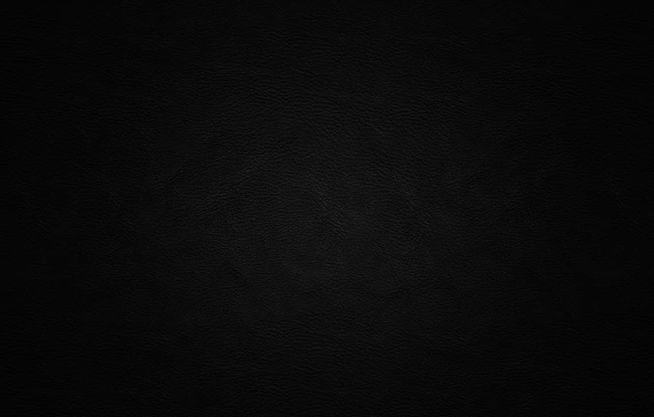 Black Leather 桌布 壁紙 — 柔軟燈光下黑色光滑皮革表面的特寫，帶有細微的粒面紋理。