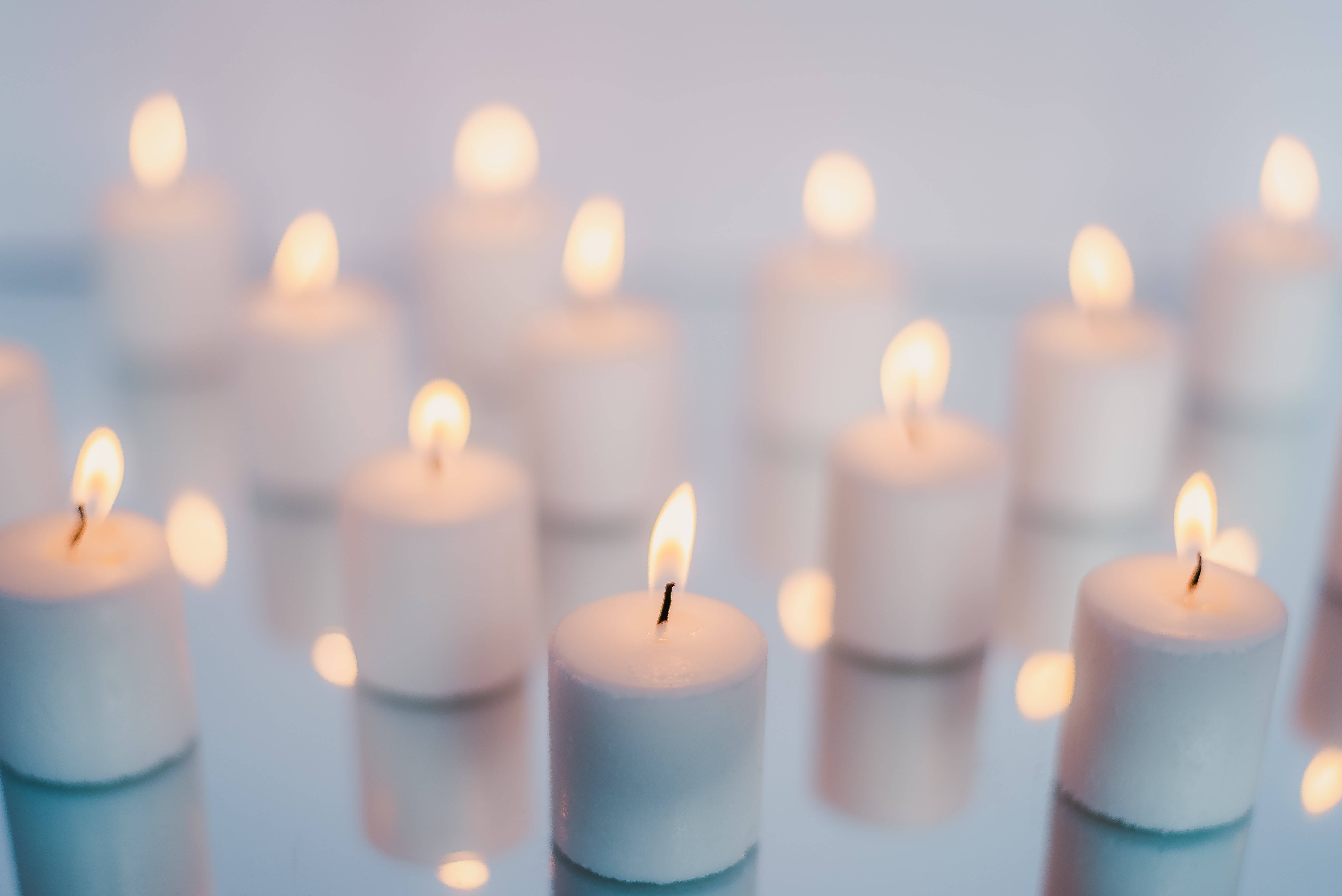 Light 桌布 壁紙 — 柔軟發光的白色蠟燭排列在反光表面上，營造出寧靜祥和的氛圍。