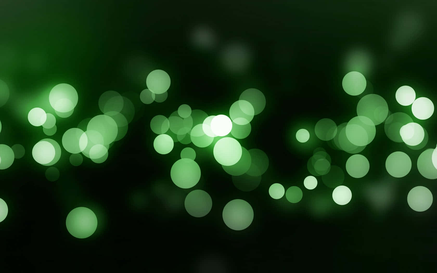 Bokeh 桌布 壁紙 — 柔軟發光的綠色球體漂浮在黑暗背景上，營造出夢幻般的散景效果。