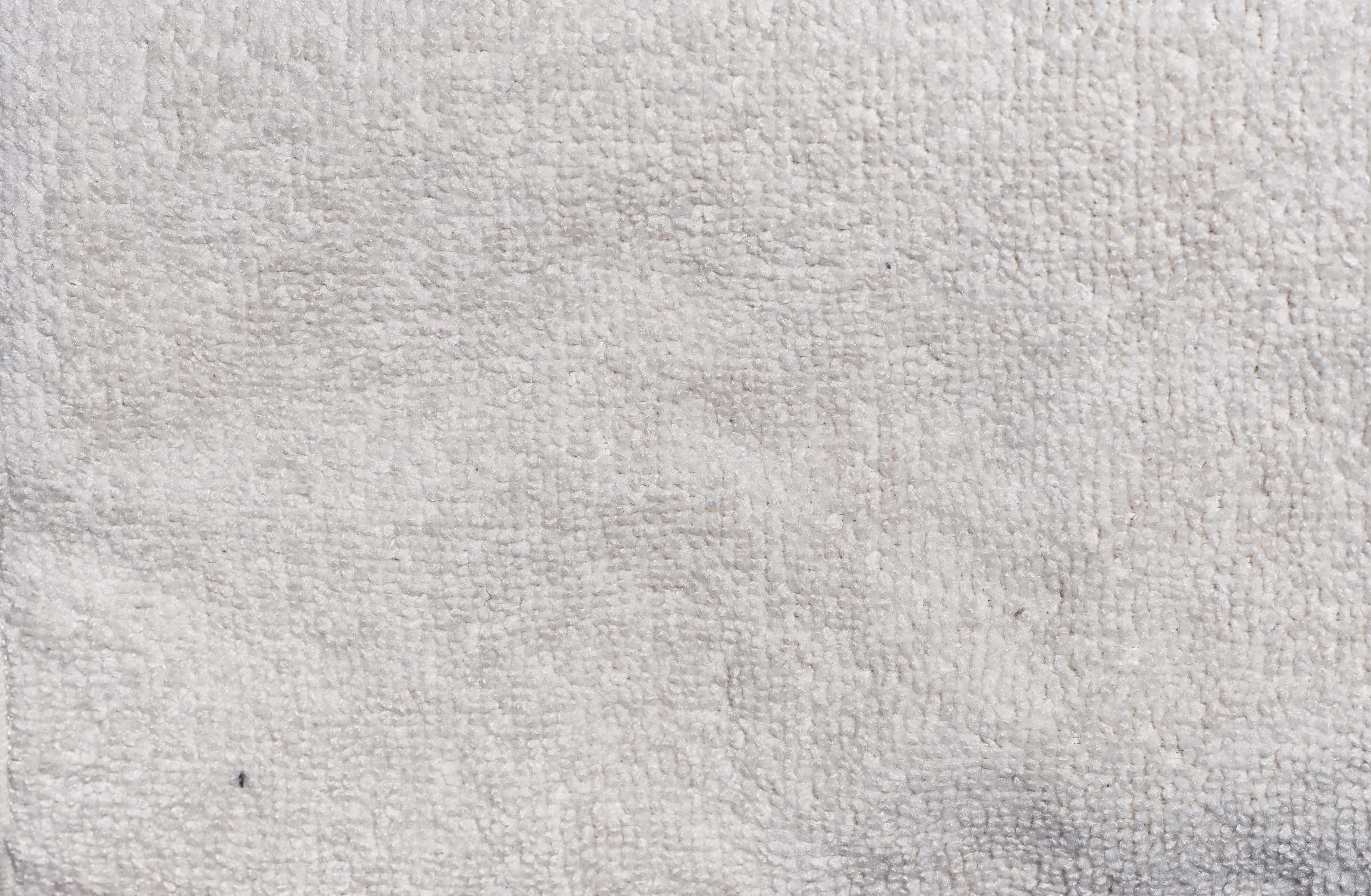 Fabric 桌布 壁紙 — 柔軟白色紋理毛巾表面的特寫，帶有細微皺褶和輕微污漬。