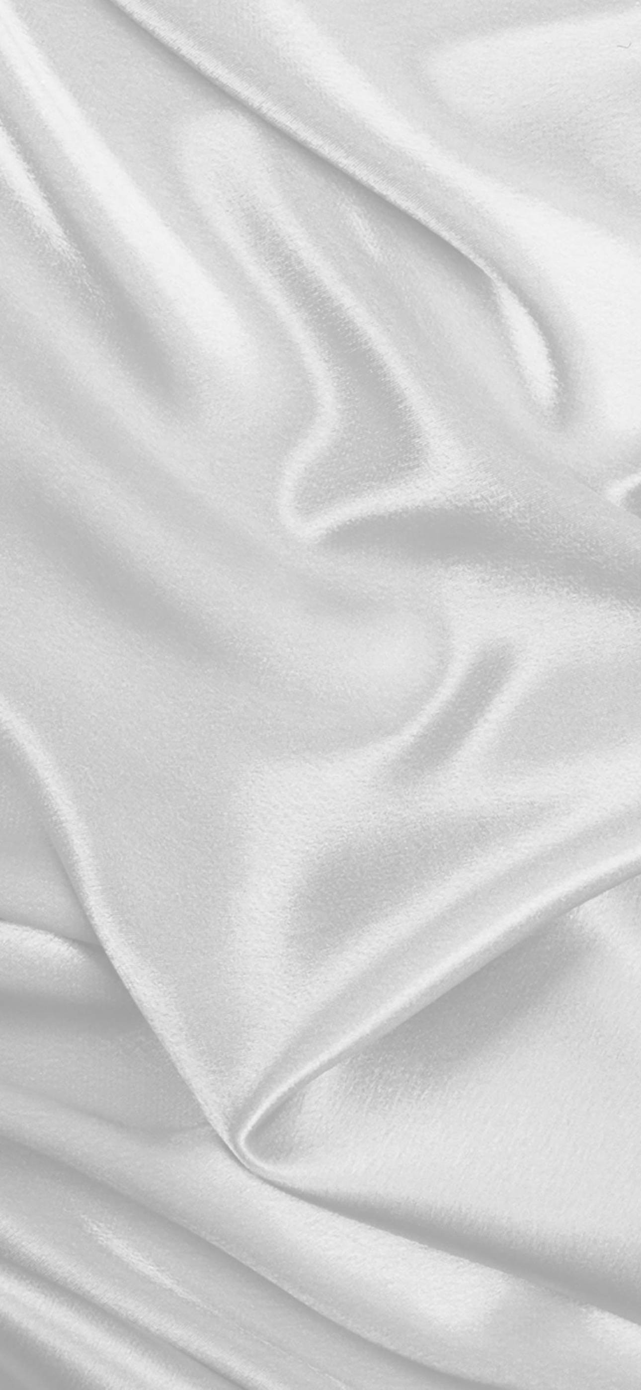 White iPhone 桌布 壁紙 — 柔軟白色緞面布料特寫，在均勻光線下呈現柔和皺褶和細微光澤。