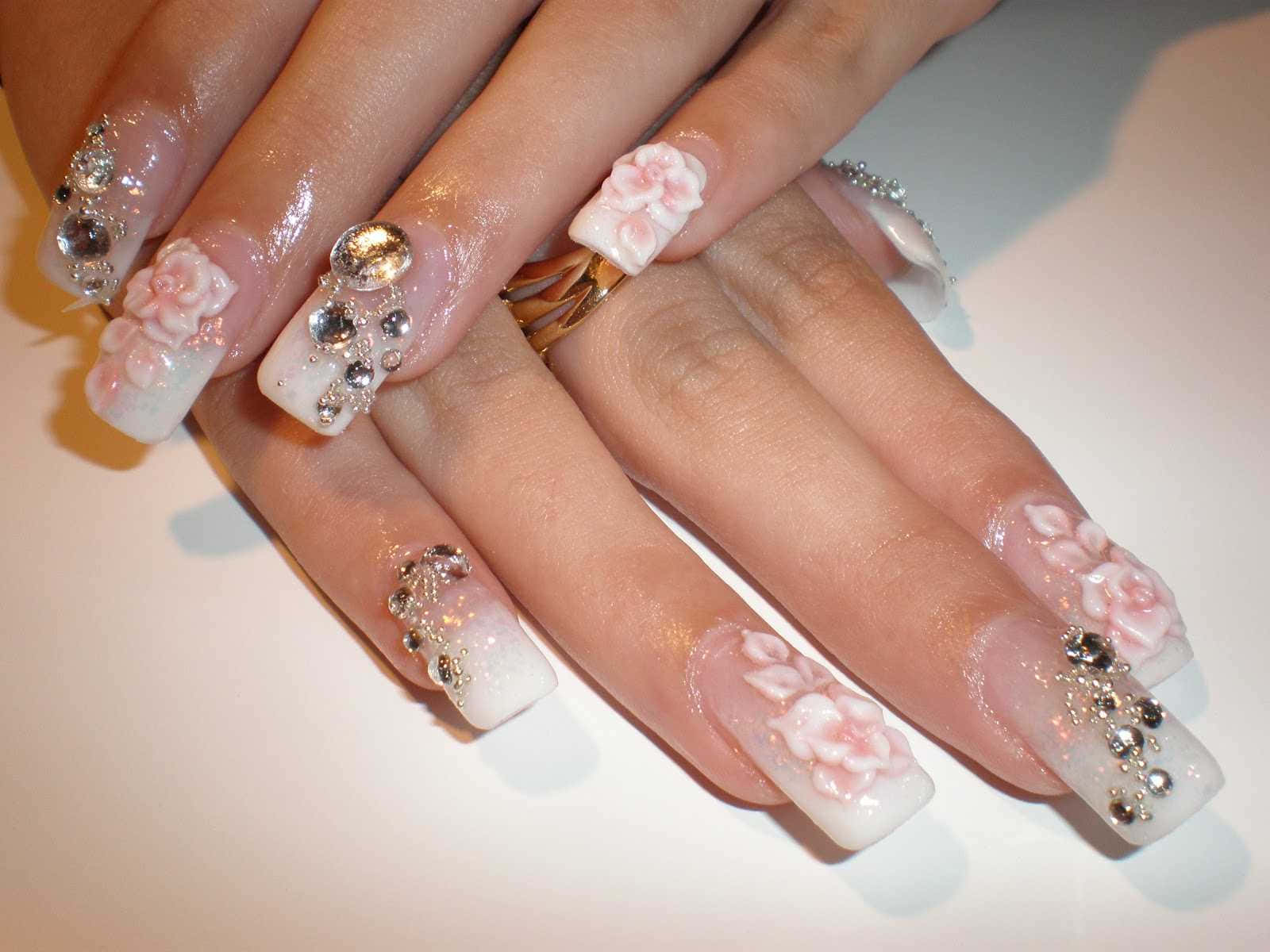 Cute Nails 桌布 壁紙 — 柔軟白色背景上優雅裝飾的指甲特寫，帶有粉紅色花卉設計和閃亮水鑽。