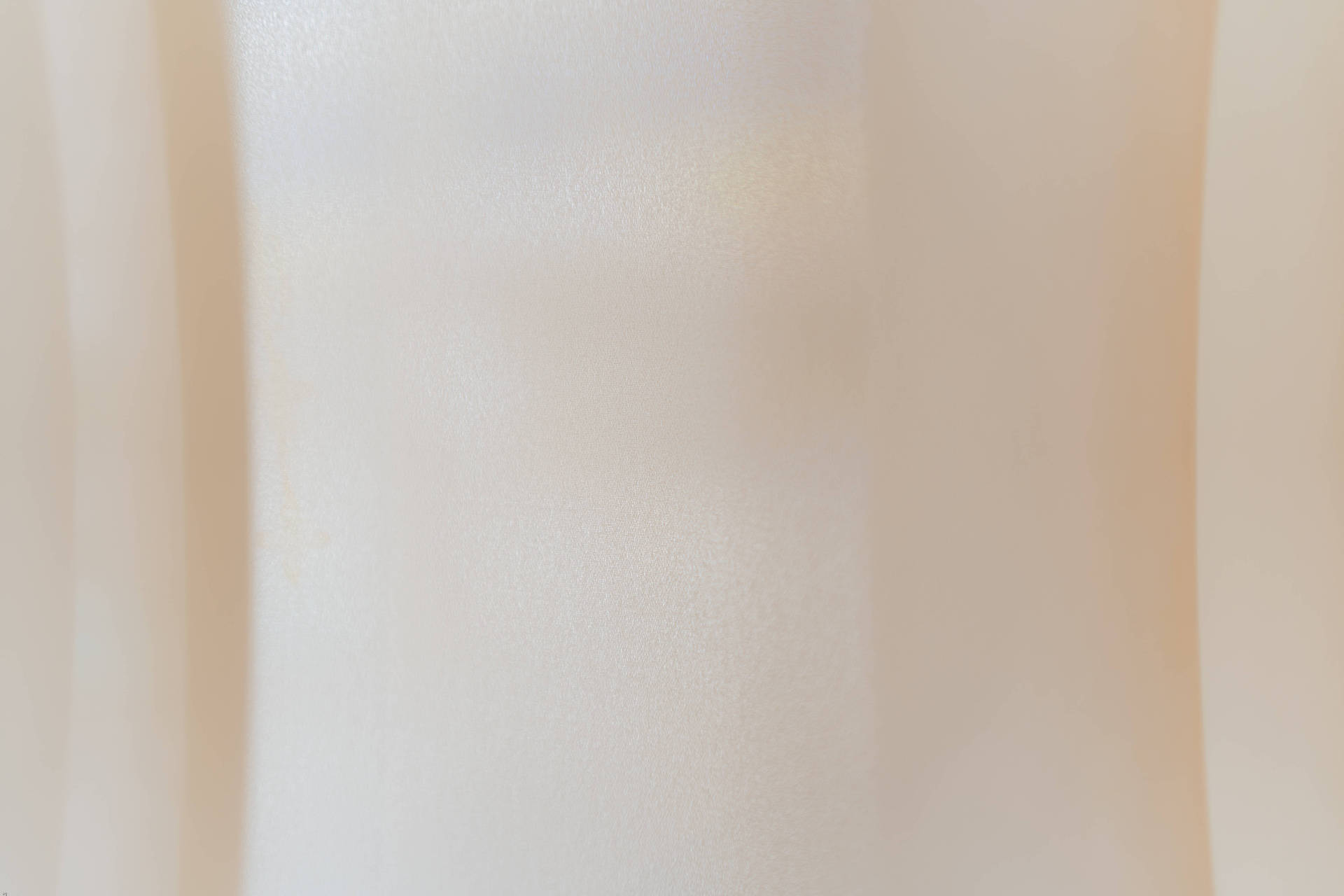 Beige Minimalist 桌布 壁紙 — 柔軟的奶油色布料，帶有柔和皺褶和細微質感，在溫暖環境光下。