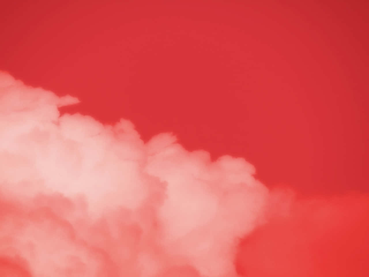Soft Red Aesthetic 桌布 壁紙 — 柔軟的棉花狀雲朵在鮮紅色的天空中飄移，營造出寧靜的大氣場景。