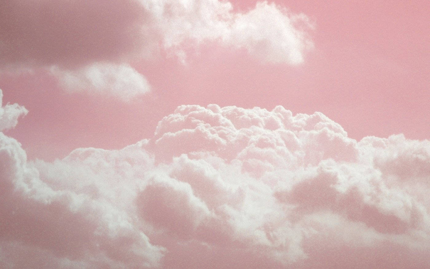 Pink Clouds 桌布 壁紙 — 柔軟的棉花狀雲朵飄過夢幻的粉彩粉紅天空，營造出寧靜的氛圍場景。