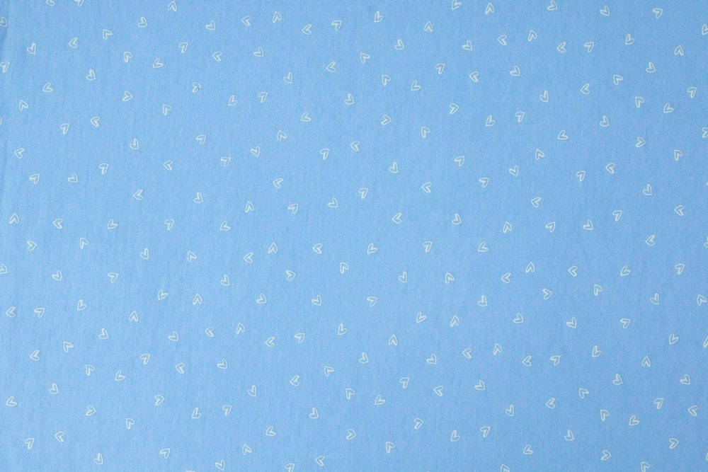 Dot 桌布 壁紙 — 柔軟的淺藍色布料上散佈著精緻的白色心形輪廓，營造出溫柔浪漫的圖案。