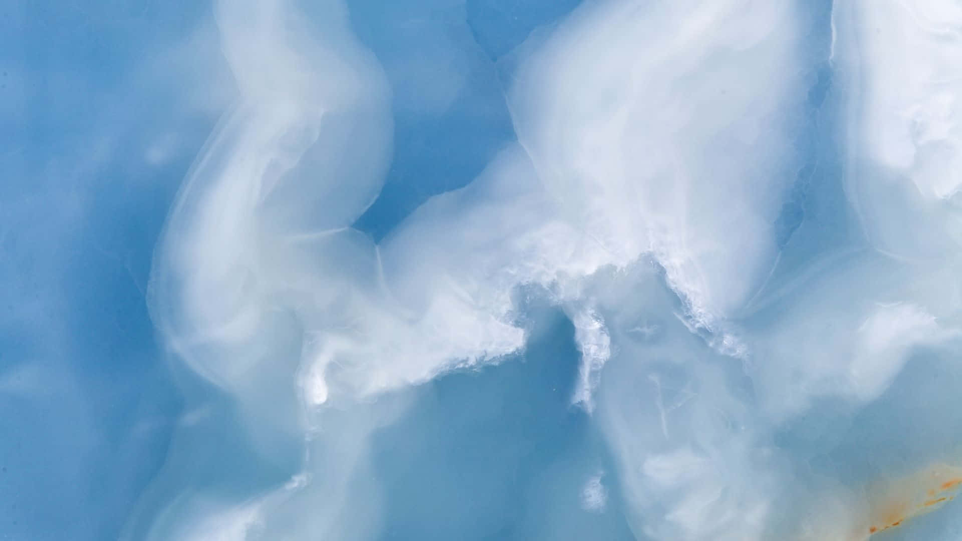 Blue Marble 桌布 壁紙 — 柔軟的白色漩渦雲在寧靜的淺藍色天空中飄移，形成平靜的抽象構圖。