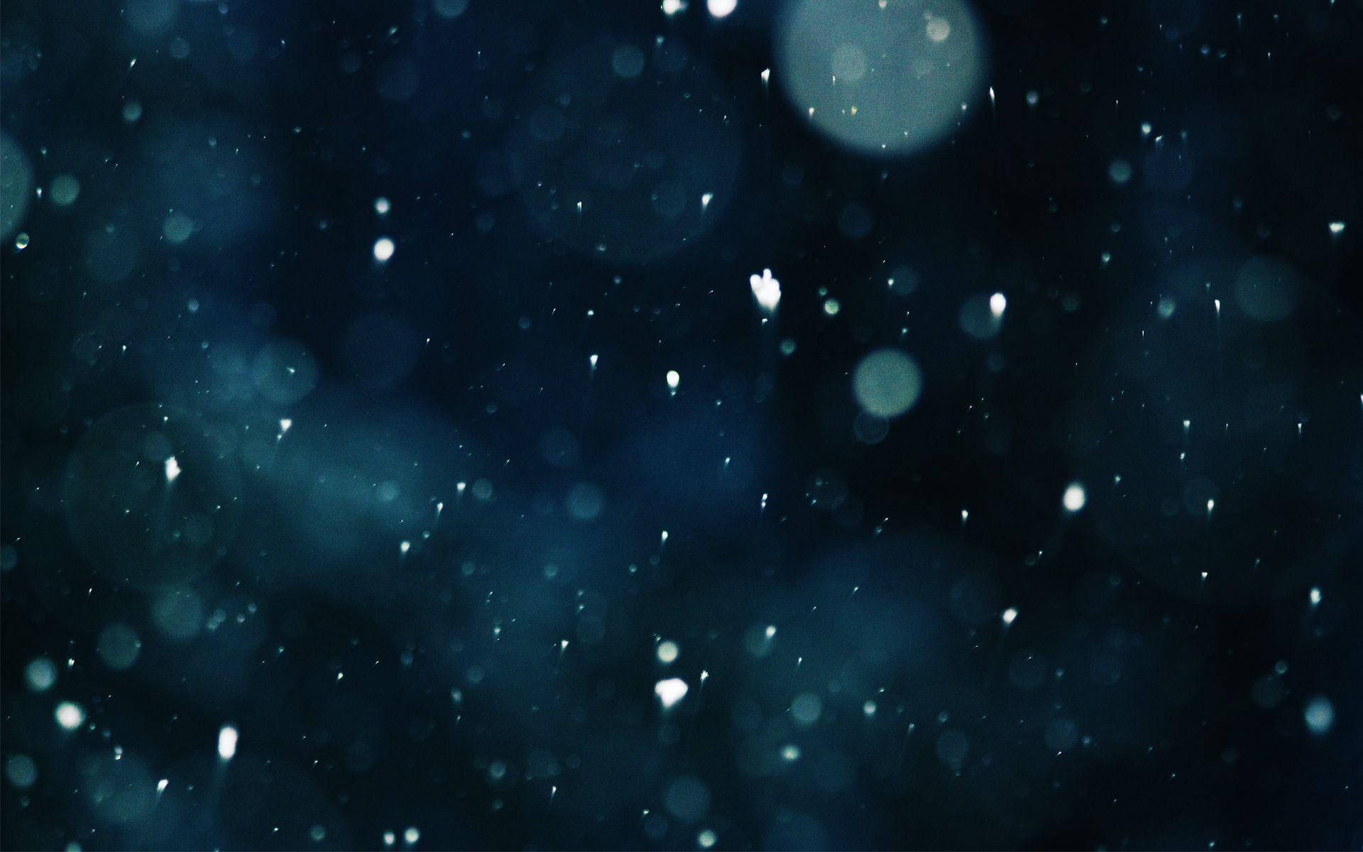 桌布 壁紙 — 柔軟的白色雪花在深藍色模糊背景中飄動，伴隨著發光的散景燈光。