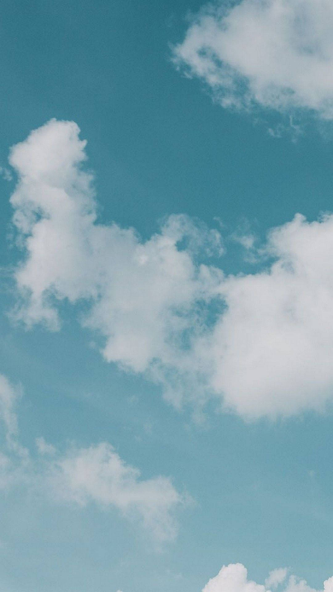 美學平板 桌布 壁紙 — 柔軟的白雲在寧靜的藍綠色天空中懶洋洋地飄浮，構成一個平靜的日間場景。