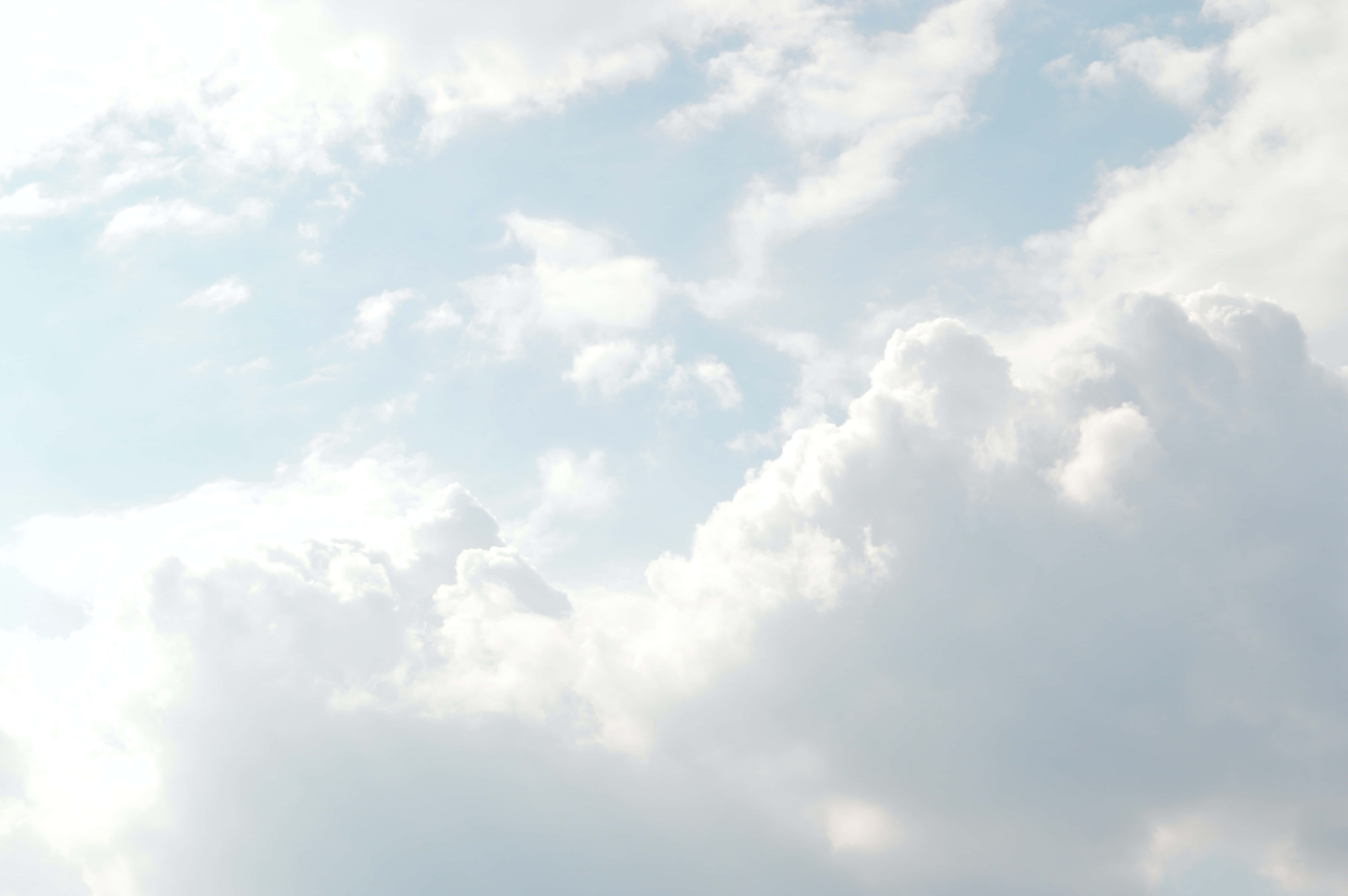 雲朵 桌布 壁紙 — 柔軟的白雲飄過淡藍色的天空，溫和的陽光穿透而過。