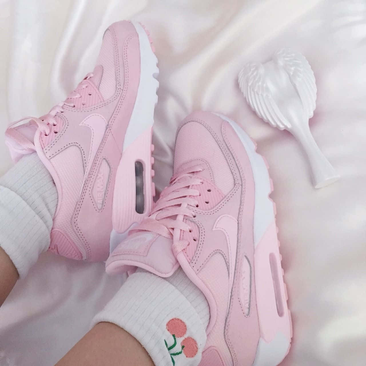Pink Shoes 桌布 壁紙 — 柔軟的粉紅色Nike Air Max運動鞋放在白色緞面床單上，旁邊有一把白色心形髮刷。