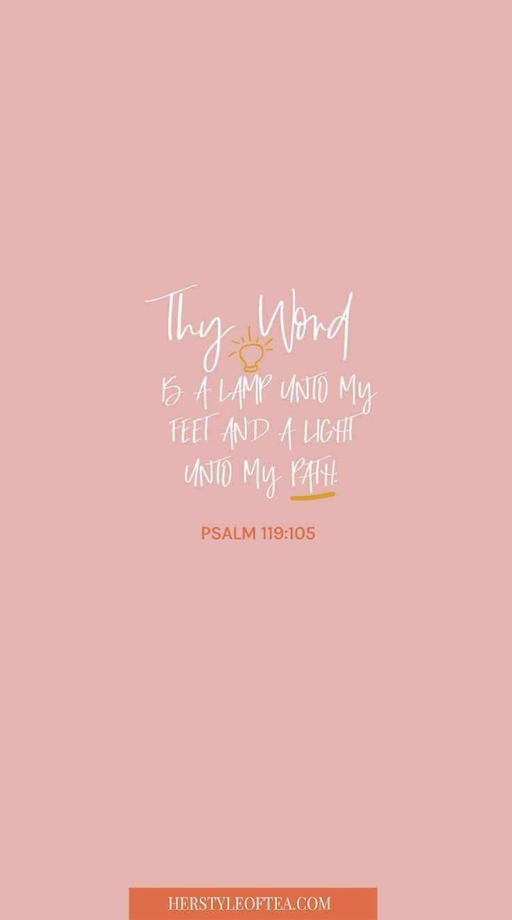 Girly Bible Verse 桌布 壁紙 — 柔軟的粉紅色壁紙，上面有白色草書文字寫著「Thy Word is a lamp unto my feet and a light unto my path」，下方有一個小燈泡圖示和「PSALM 119:105」。