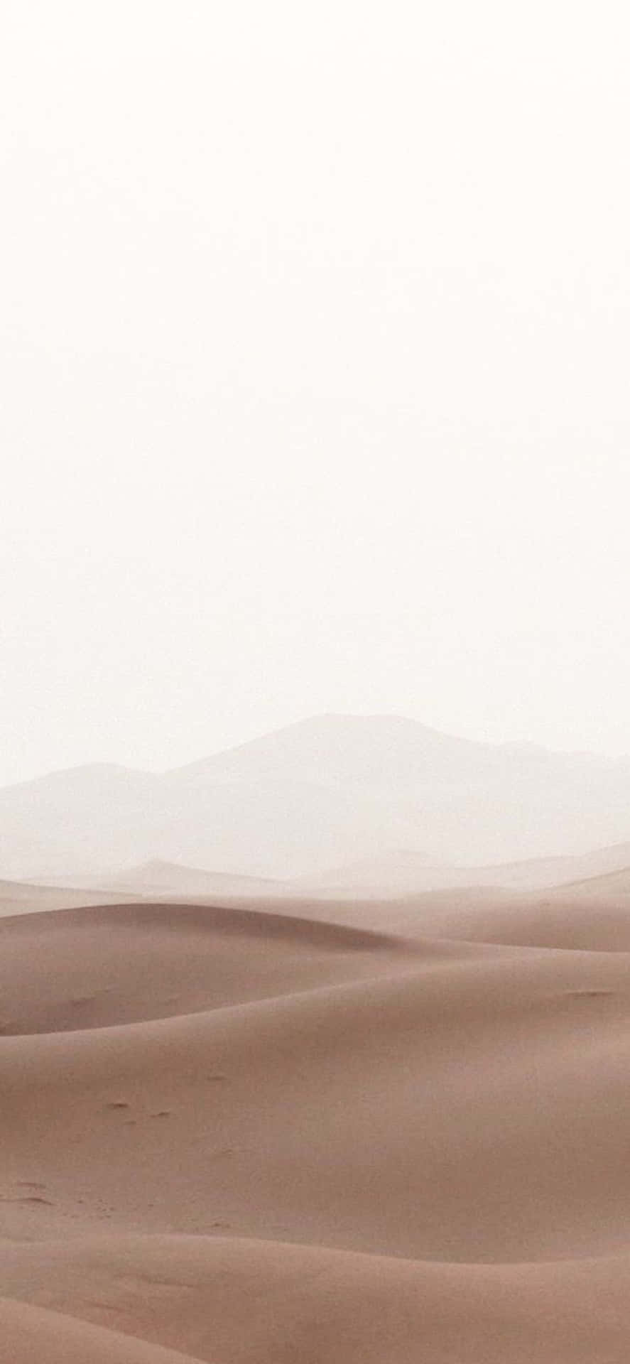iPhone X Minimal 桌布 壁紙 — 柔軟的粉紅色沙丘在蒼白的天空下延伸至朦朧的遠山。