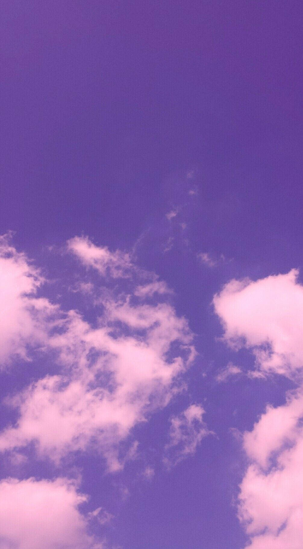 iPhone 桌布 壁紙 — 柔軟的粉紅雲朵在夢幻般的紫色暮色天空中飄移，構成寧靜的天體場景。