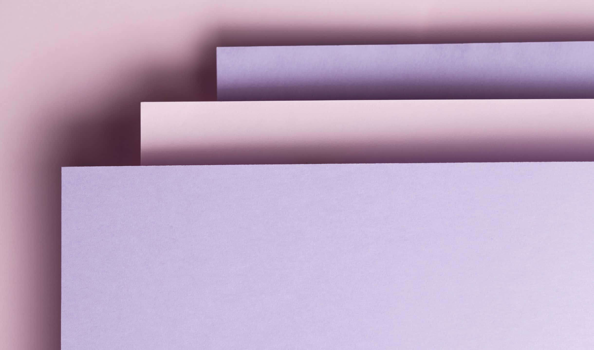 2440x1440 Material 桌布 壁紙 — 柔軟的薰衣草和紫紅色調的紋理紙張堆疊，營造出帶有柔和陰影的極簡構圖。