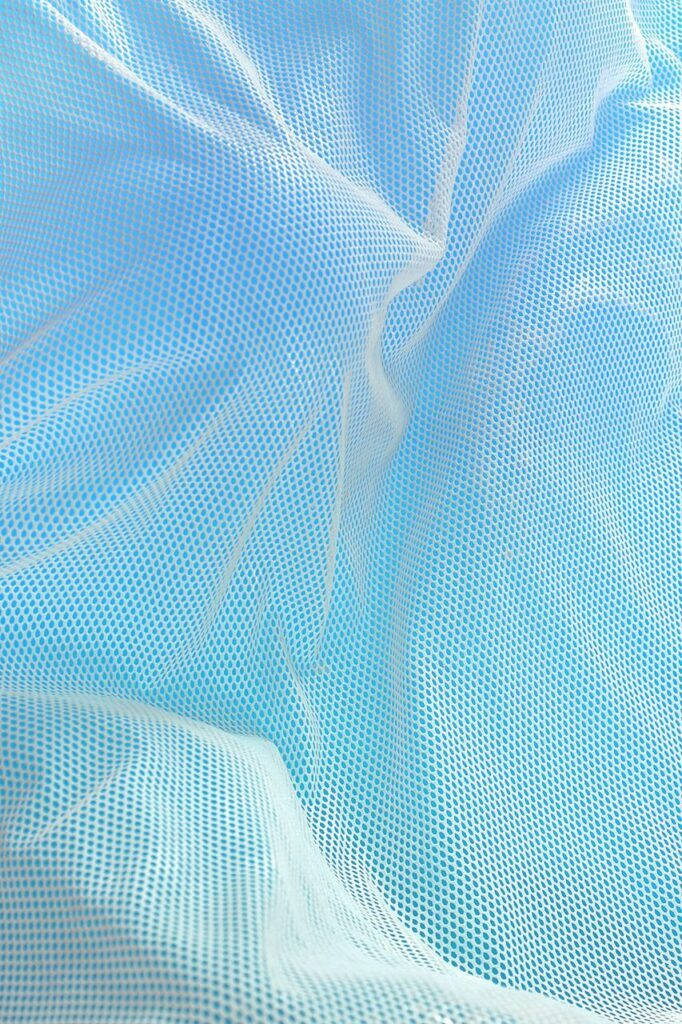 Blue Pastel Aesthetic 桌布 壁紙 — 柔軟的藍色網眼布料，帶有細膩的褶皺和精細的網格圖案，營造出柔和、輕盈的質感。