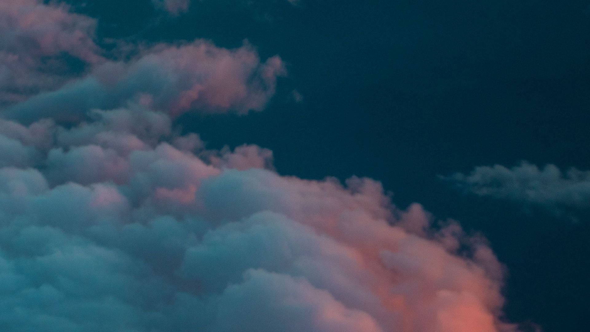 View 桌布 壁紙 — 柔軟的雲朵在深沉的暮色天空中散發出粉紅色和藍綠色的光芒。