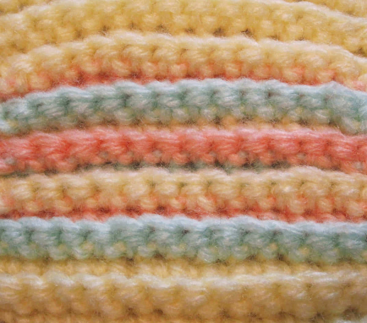 Crochet 桌布 壁紙 — 柔軟粉彩條紋鉤針織物的特寫，帶有黃色、蜜桃、薄荷和奶油色調。