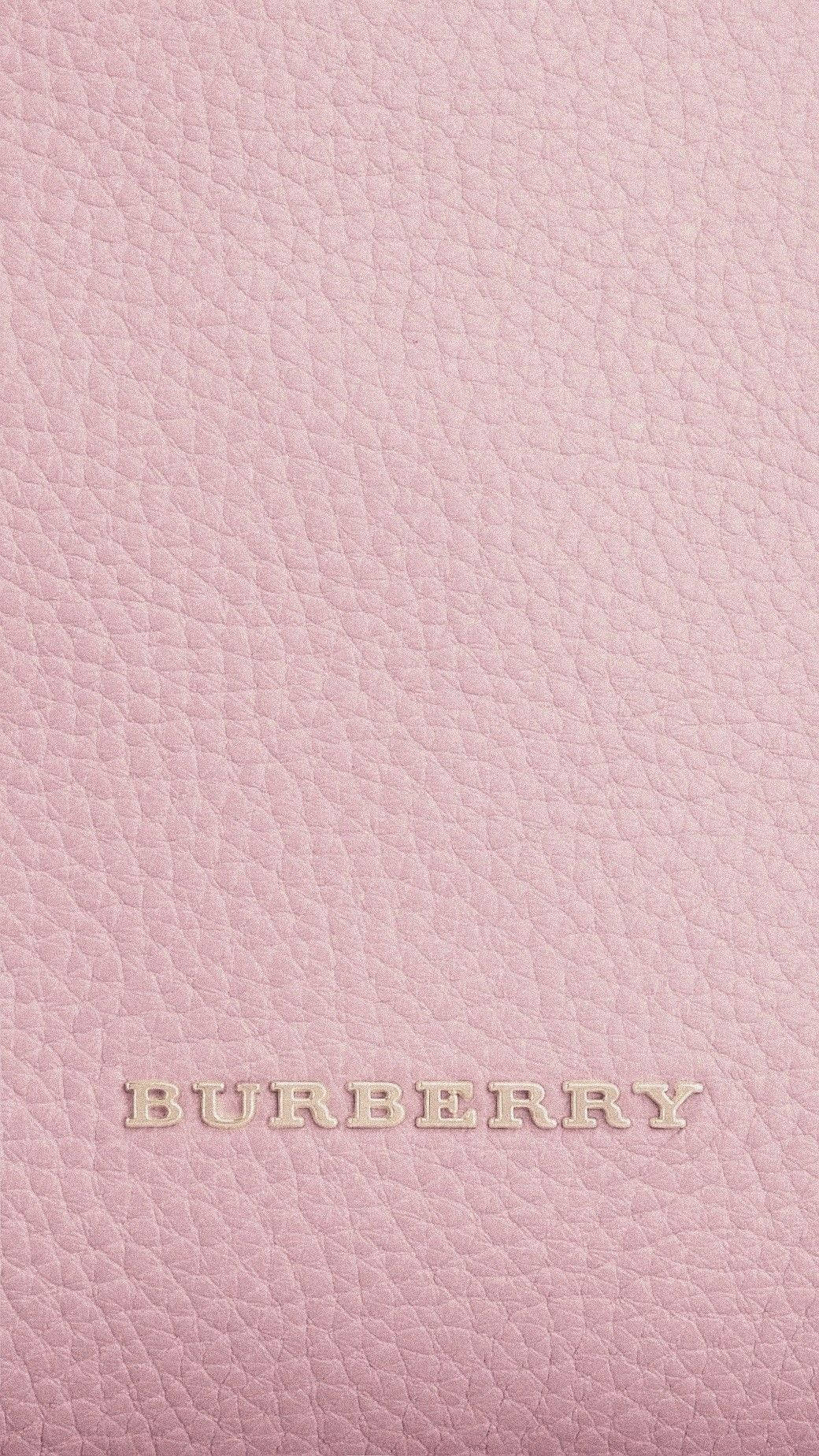 Burberry 桌布 壁紙 — 柔軟粉紅色紋理皮革的特寫，帶有金屬金色壓印的 Burberry 標誌。