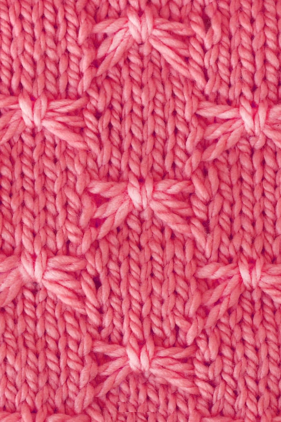 Butterfly Stitch 桌布 壁紙 — 柔軟粉紅色針織布料的特寫，帶有複雜的紋理圖案和可見的紗線纖維。