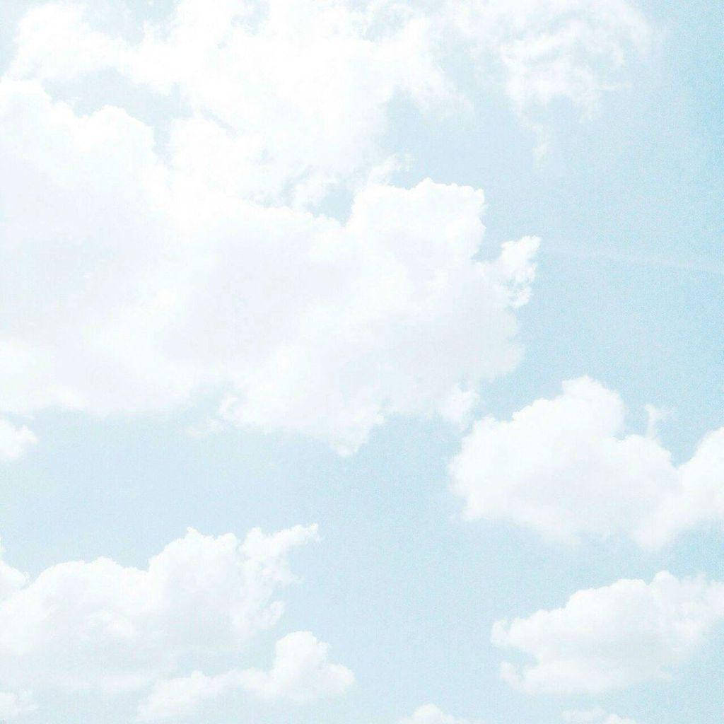 Aesthetic Cloud 桌布 壁紙 — 柔軟蓬鬆的白雲懶洋洋地飄過淡藍色的天空，帶有柔和的復古底片顆粒紋理。
