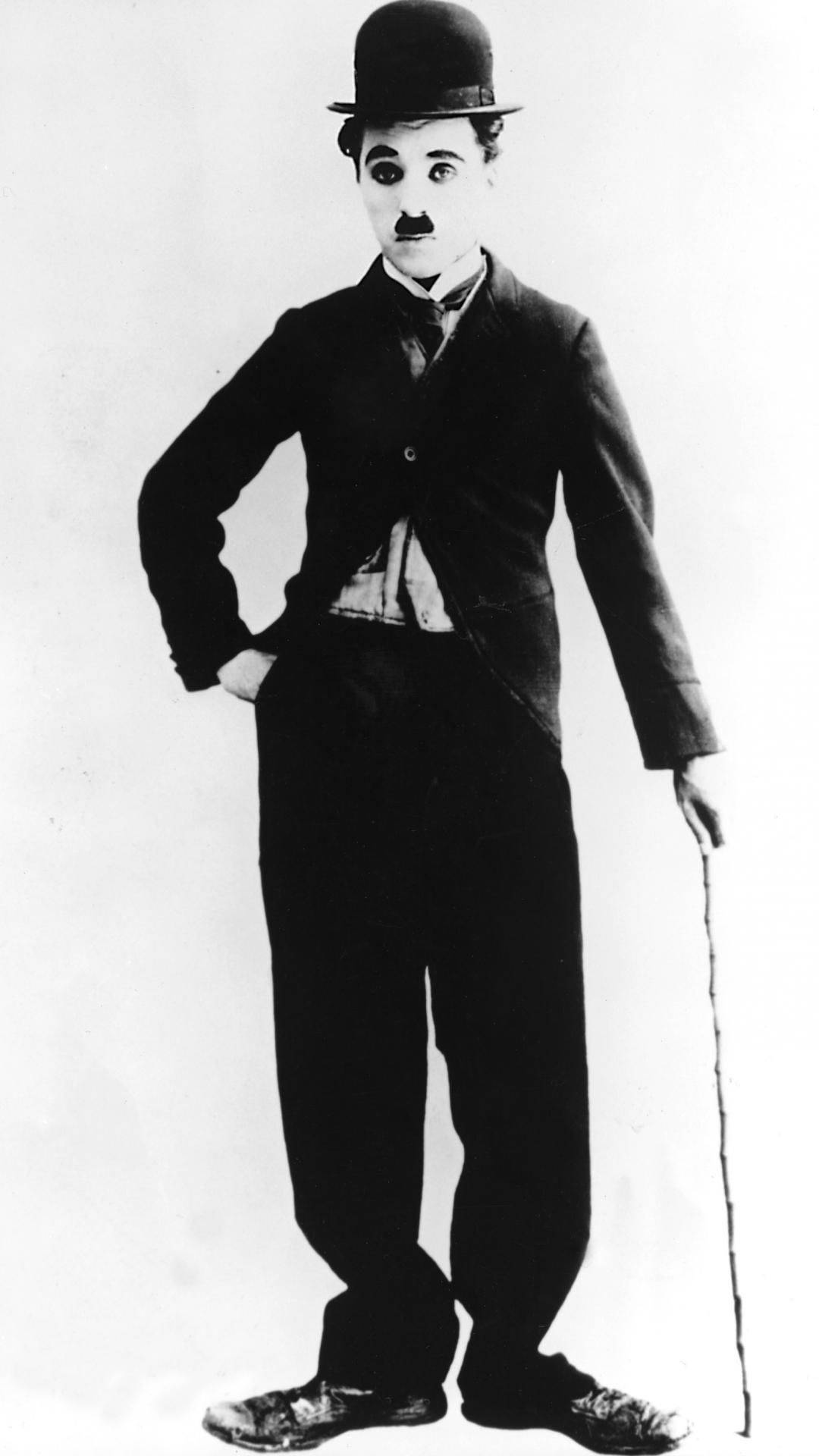 Chaplin 桌布 壁紙 — 查理·卓別林的經典黑白肖像，戴著標誌性的圓頂禮帽和手杖，自信地擺姿勢。