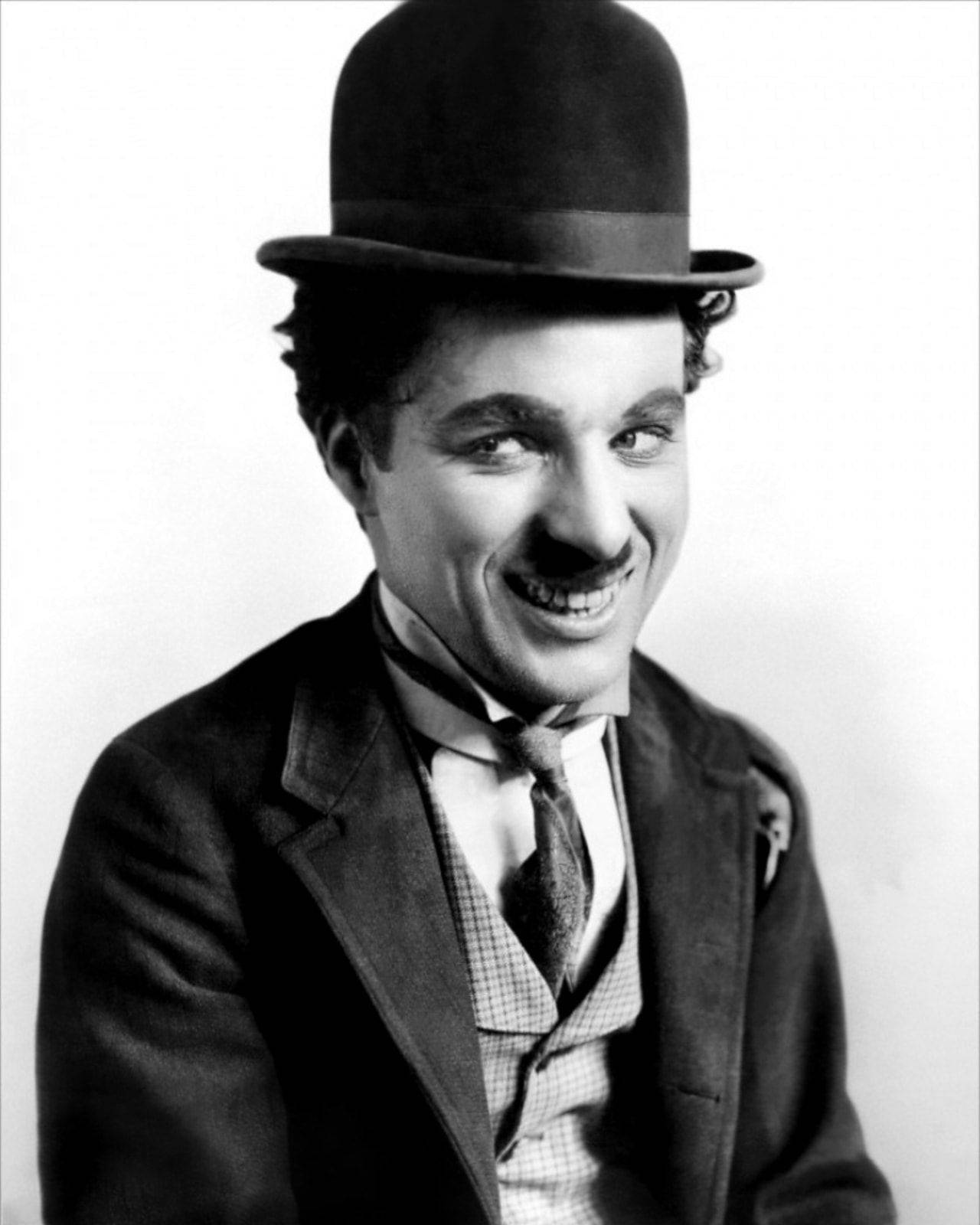 Chaplin 桌布 壁紙 — 查理·卓別林經典黑白肖像，戴著標誌性的圓頂禮帽和西裝，溫暖微笑。