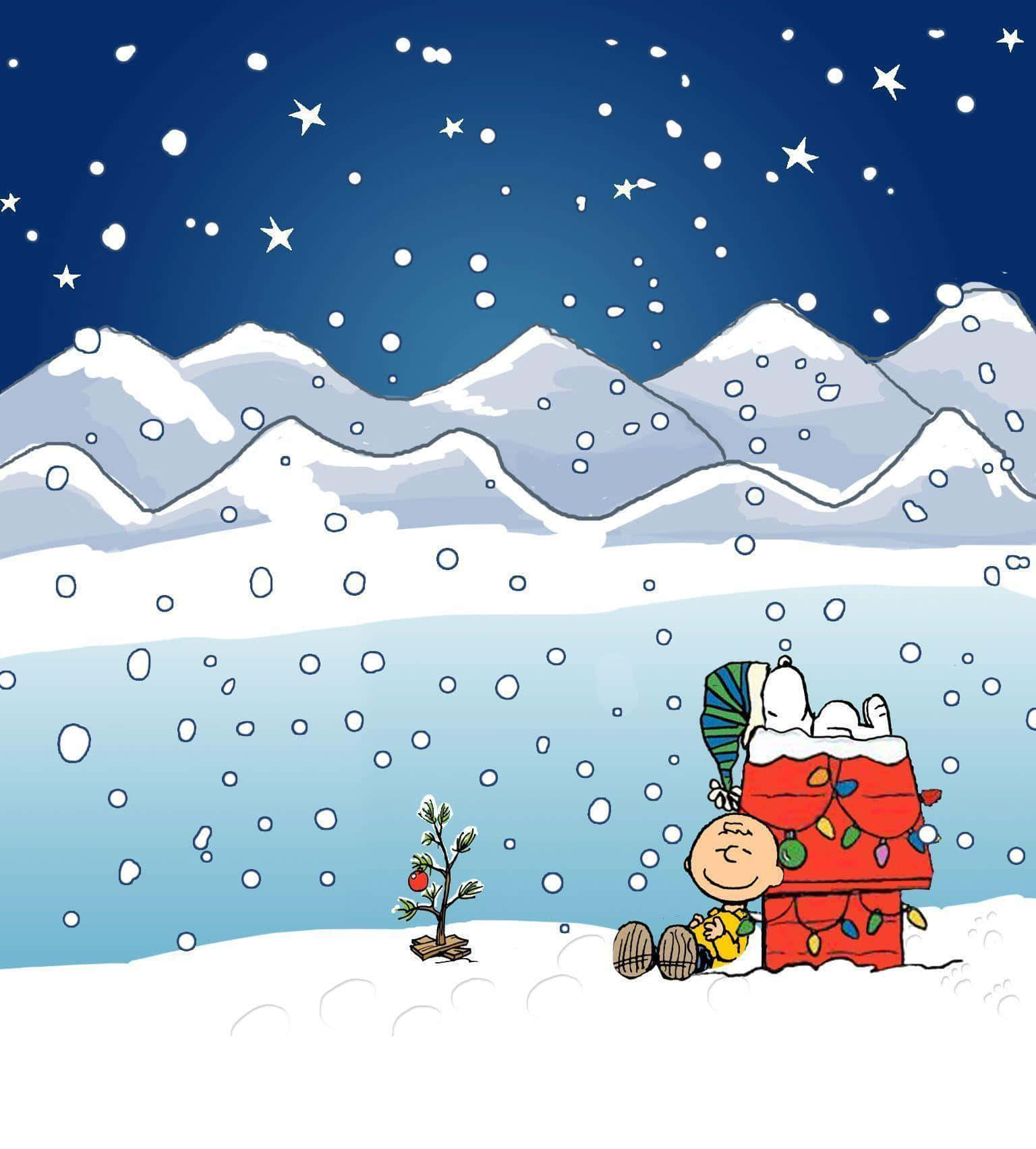 Peanuts Christmas 桌布 壁紙 — 查理布朗和史努比在雪花下依偎在一棵小小的裝飾樹旁，背景是白雪覆蓋的山脈和繁星點點的夜空。