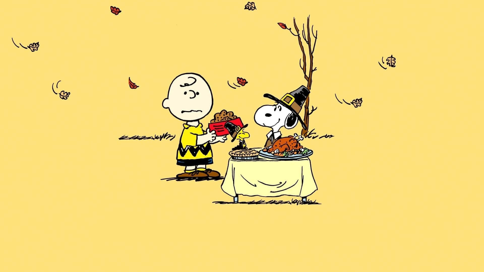 Charlie Brown Thanksgiving 桌布 壁紙 — 查理布朗和史努比戴著朝聖者帽子，在飄落的秋葉下分享感恩節大餐，有火雞和派。