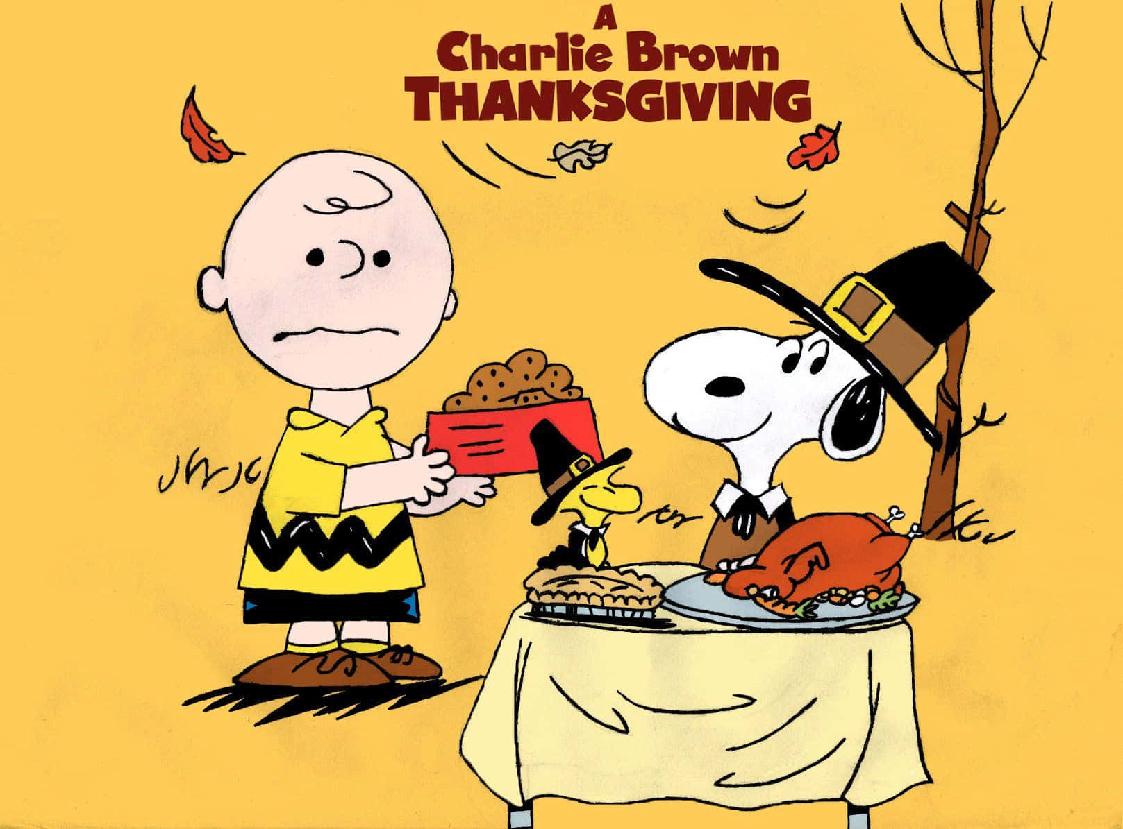 Funny Thanksgiving 桌布 壁紙 — 查理布朗和史努比穿著感恩節服裝，站在一張放有火雞派和餅乾的桌子旁，背景是黃色的秋天。