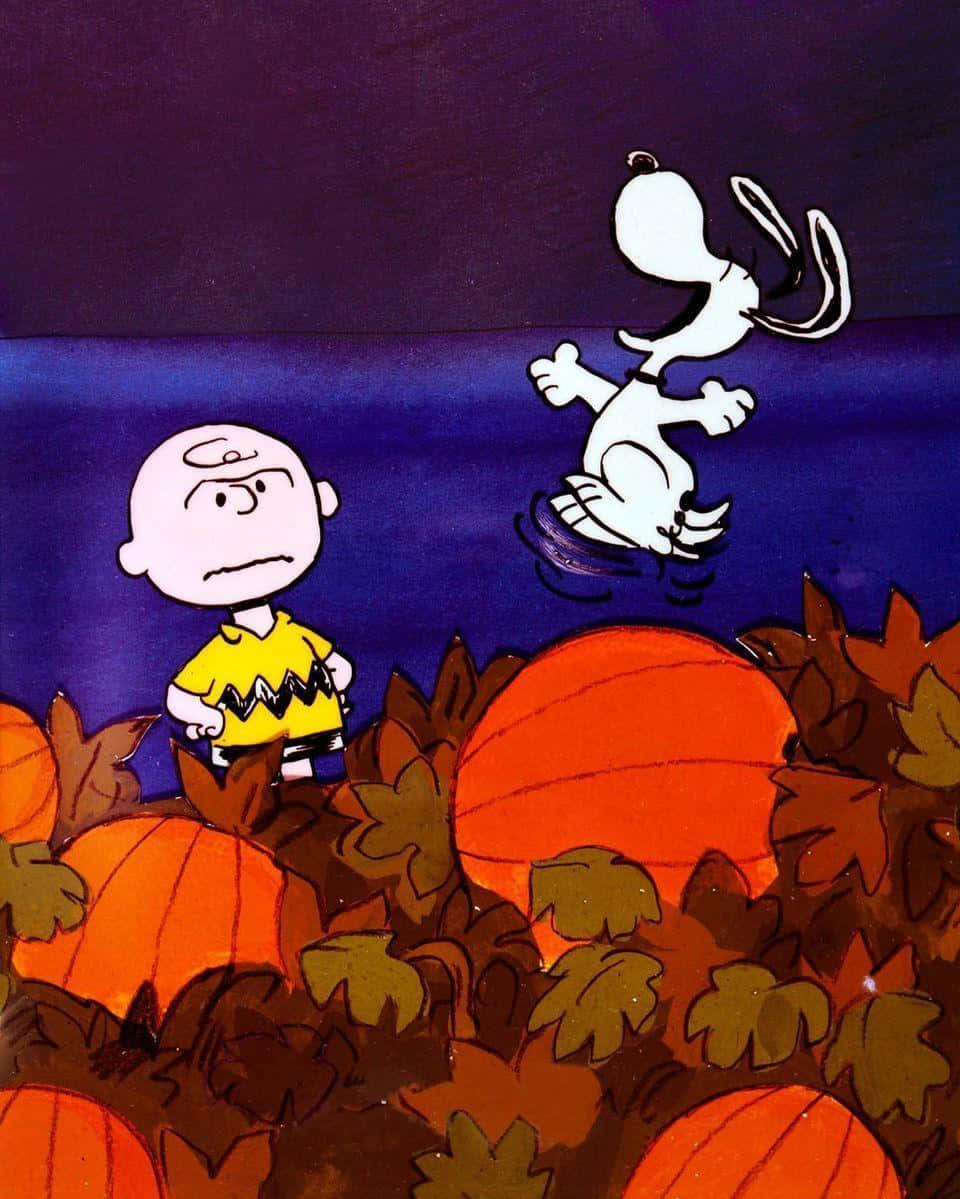 The Great Pumpkin 桌布 壁紙 — 查理布朗站在南瓜中，史努比在深藍色的秋夜天空中快樂地飛翔。