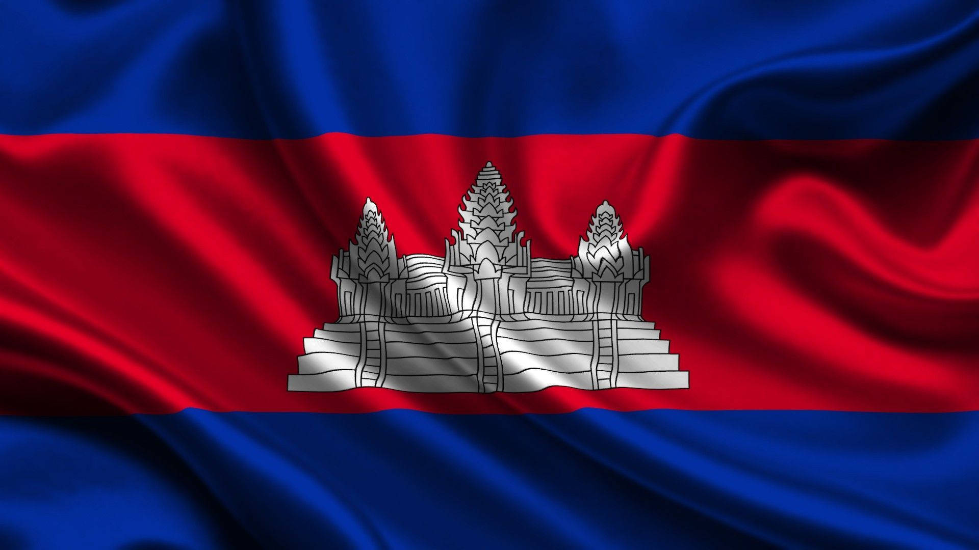 Flag 桌布 壁紙 — 柬埔寨國旗動態飄揚，帶有豐富的藍紅條紋和中央吳哥窟的銀色輪廓。