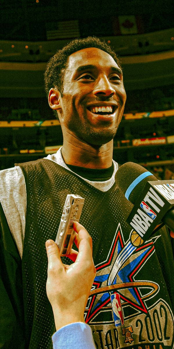 美學科比 桌布 壁紙 — 柯比·布萊恩在2002年NBA全明星賽訪問中，手持麥克風和小獎盃，滿面笑容。