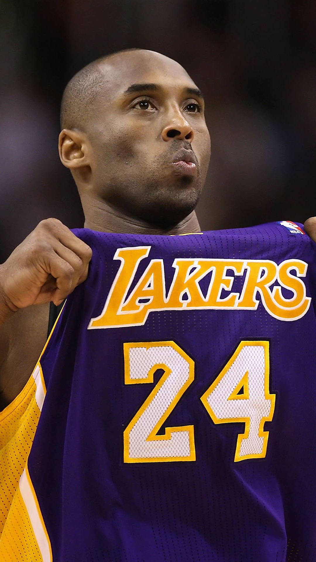 Kobe Bryant iPhone 桌布 壁紙 — 柯比布萊恩在籃球比賽中，專注地舉起他的紫金色湖人隊24號球衣。