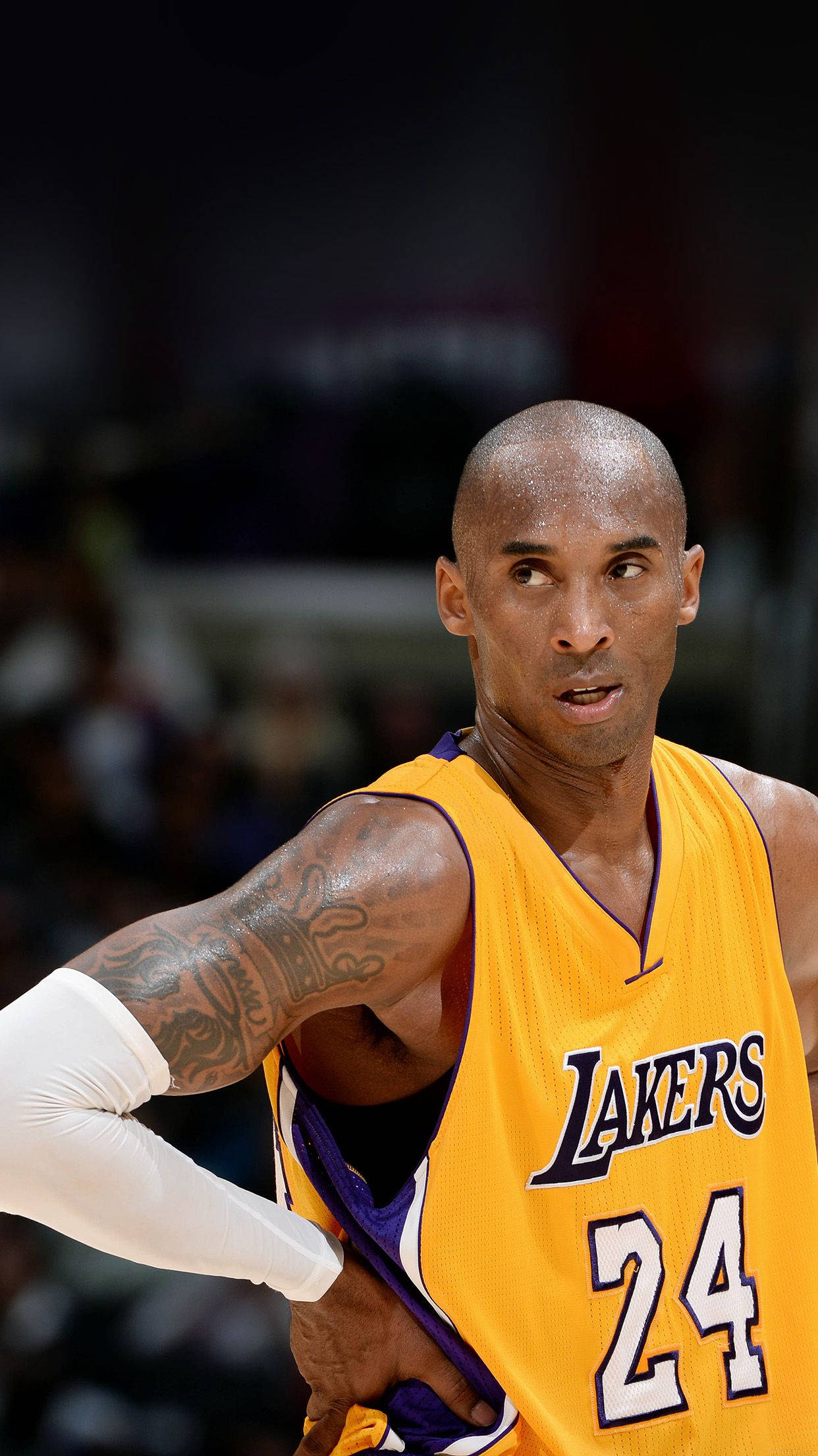 Kobe Bryant iPhone 桌布 壁紙 — 柯比布萊恩身穿黃色湖人隊24號球衣，在場館燈光下於籃球比賽中表現得極度專注。