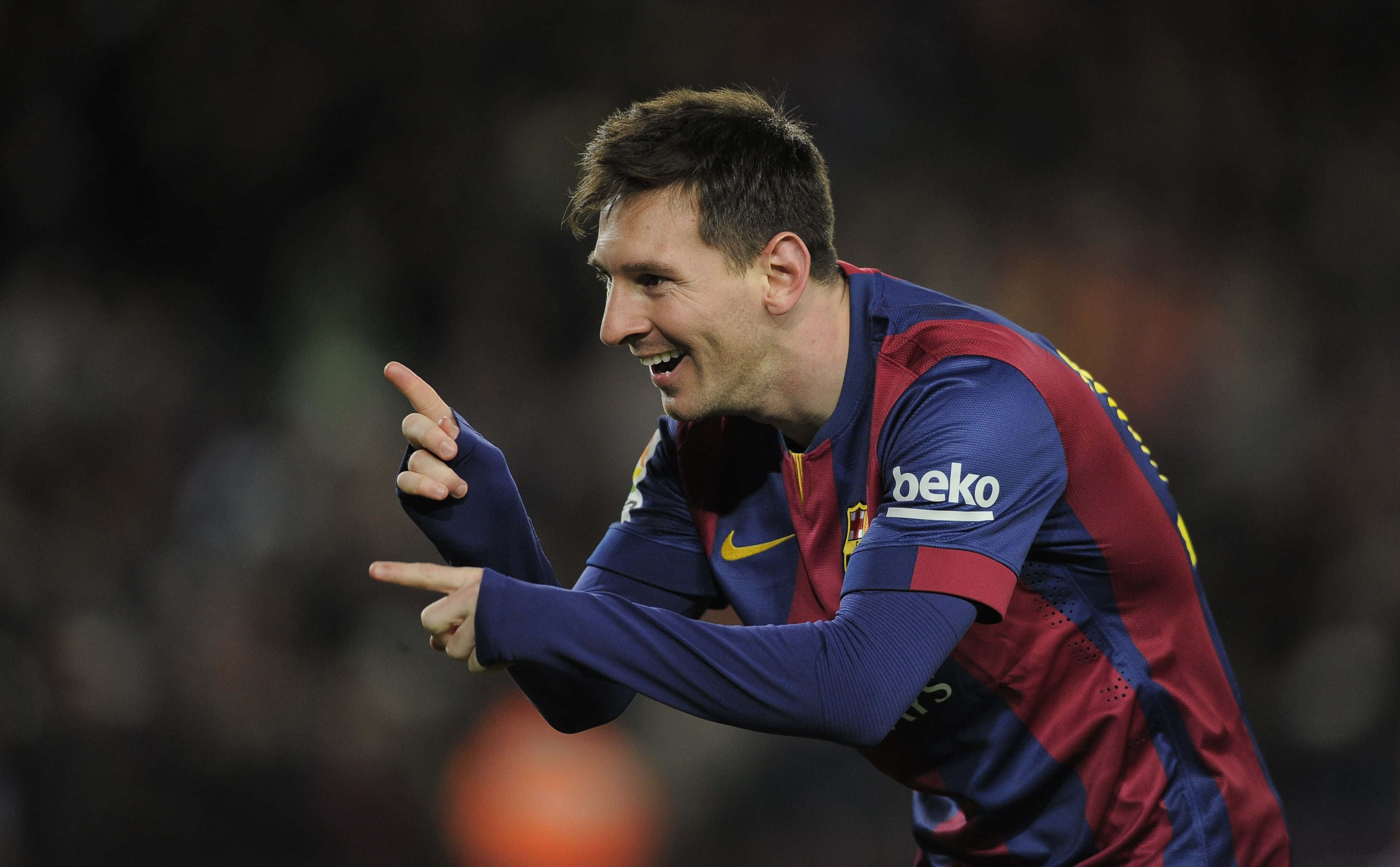 Lionel Messi Cool 桌布 壁紙 — 梅西身穿巴塞隆納球衣，在夜間比賽中微笑並興奮地指著。
