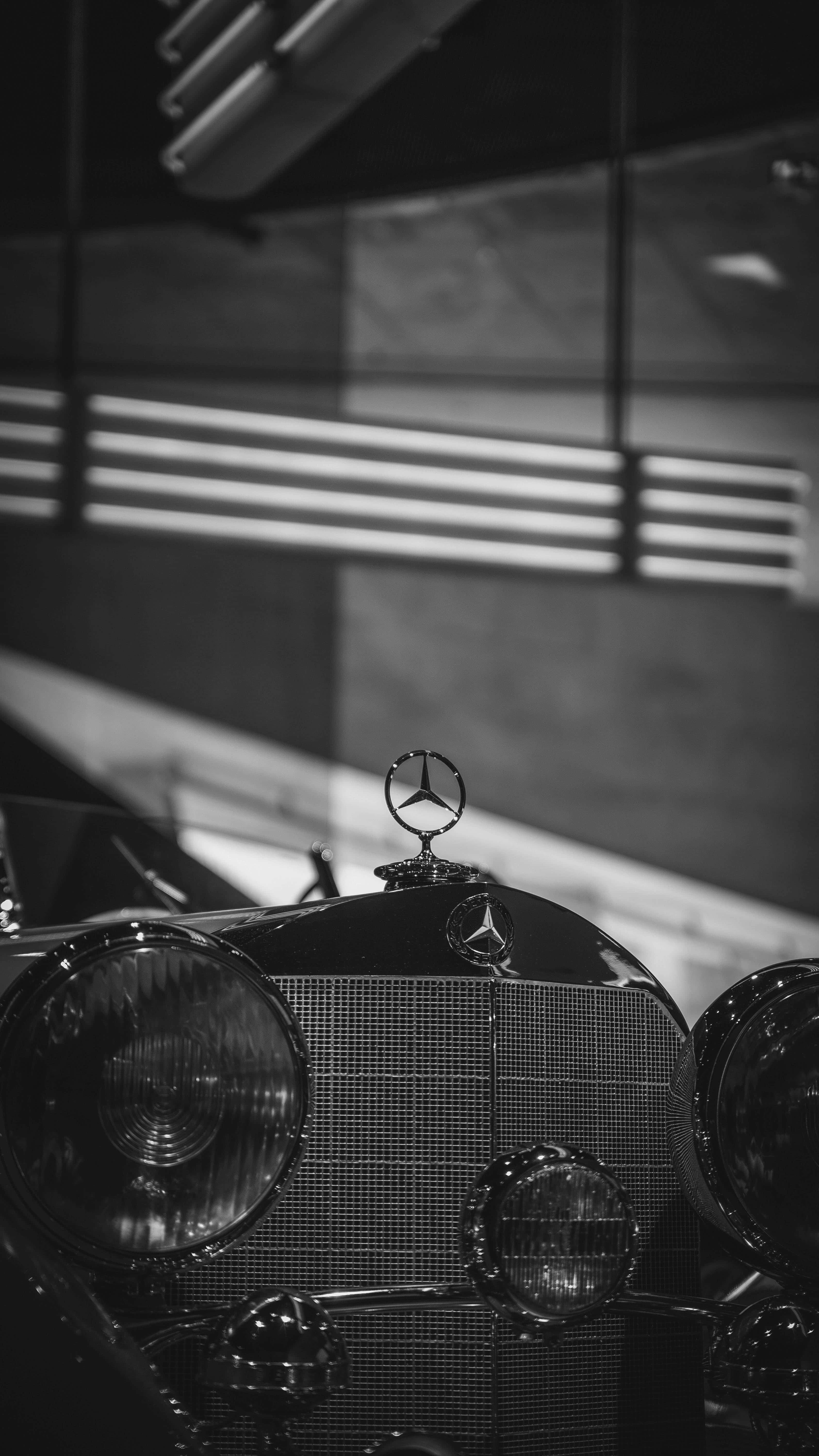 Black And White Vintage Car 桌布 壁紙 — 條紋燈光下經典賓士水箱護罩及星形標誌的黑白特寫。