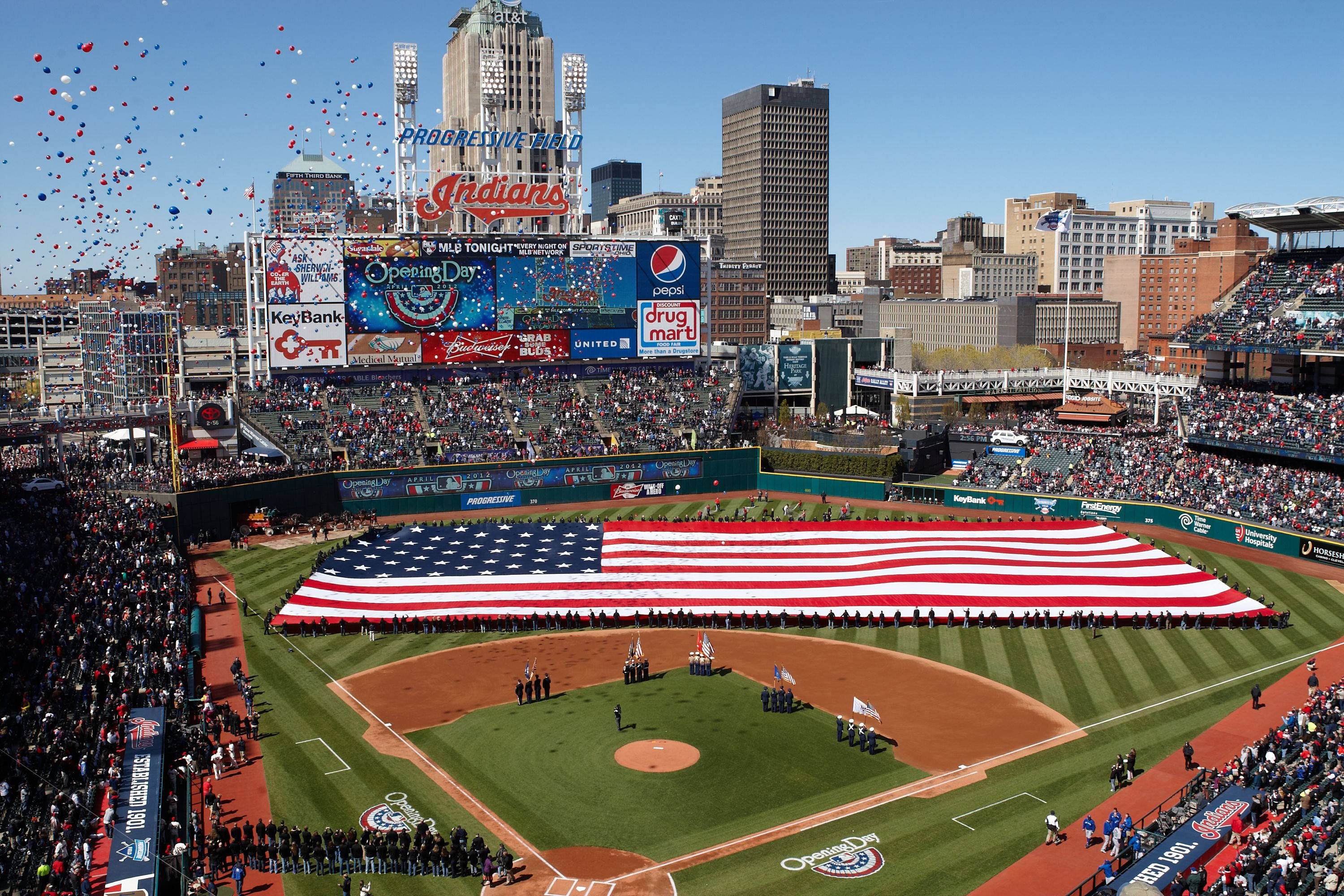 Cleveland Indians 桌布 壁紙 — 棒球場的鳥瞰圖，場內坐滿球迷，一面巨大的美國國旗在愛國儀式中展開覆蓋整個場地。