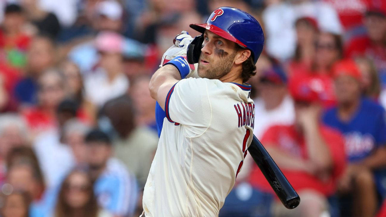 Phillies 桌布 壁紙 — 棒球選手 Bryce Harper 在球場中揮棒，背景有模糊的紅色和藍色球迷。