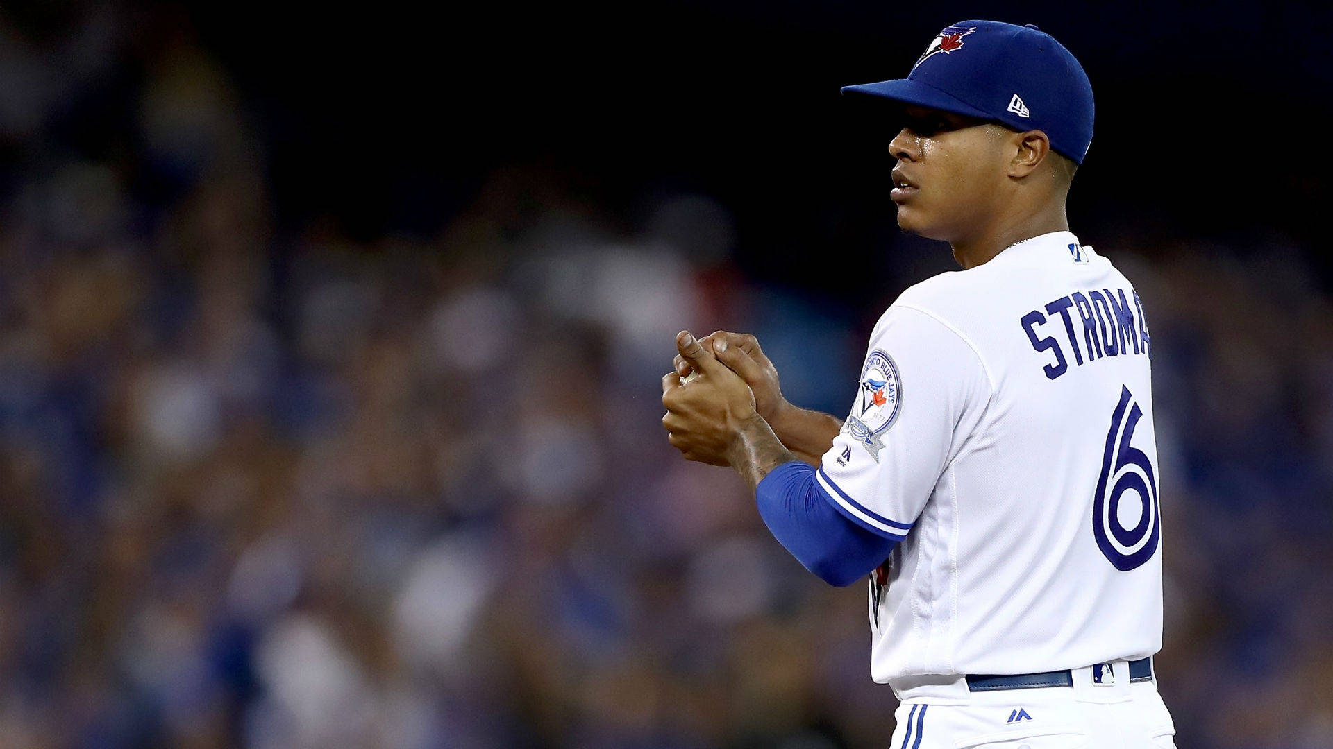 Marcus Stroman 桌布 壁紙 — 棒球選手 Jose Suarez 在明亮燈光下的球場拍手，背後是模糊的人群。