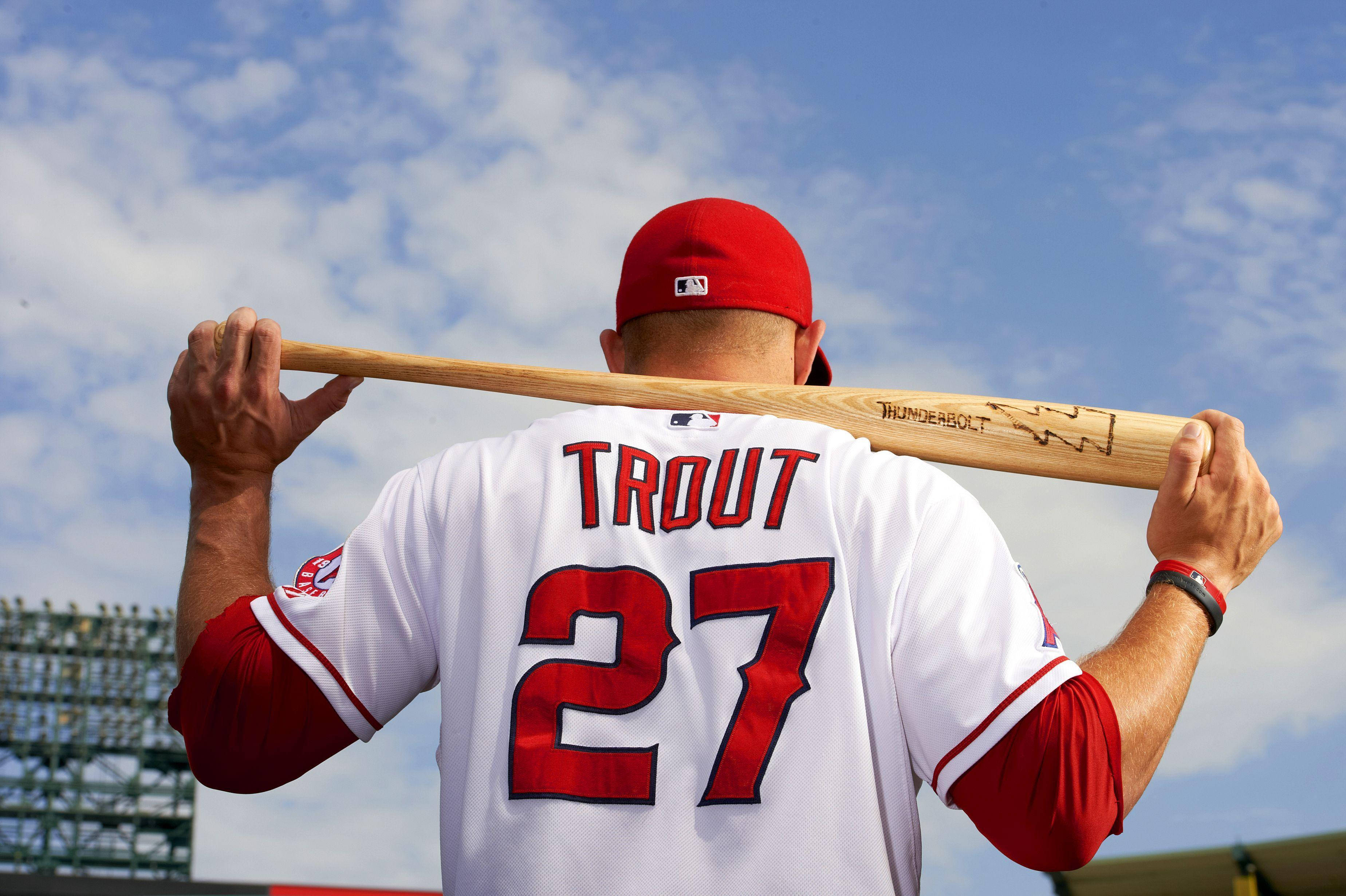 Mike Trout 桌布 壁紙 — 棒球選手 Mike Trout 的背影，他將球棒扛在肩上，背景是晴朗的藍天和零星的白雲。